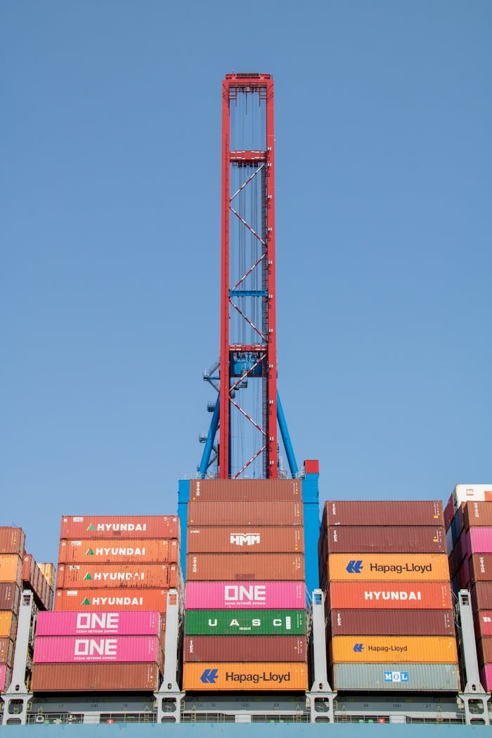 Crafting Captivating Headlines: Your awesome post title goes here Vertical view of stacked cargo containers under a tall crane at Hamburg port.